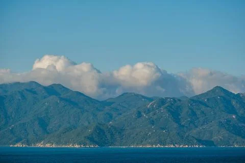 Lush Green Coastal Mountain Range Under Billowing Clouds in Vietnam Stock Photos
