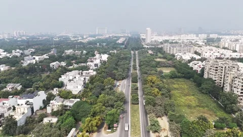 A lush green corridor cuts through Greater Noida’s residential skyline, where Stock Footage 328746175
