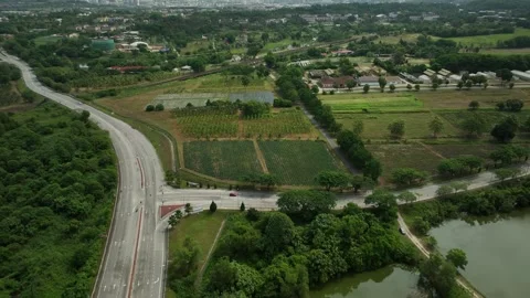 Lush green fields and winding roads in a rural landscape near a city Stock Footage 311986778