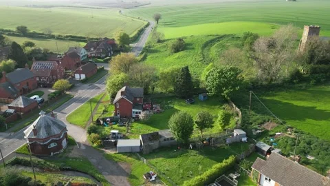 Lush green fields surround quiet village streets Vídeo Stock 346856725
