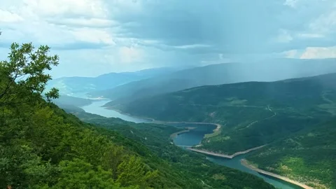 Lush green foliage frames a sweeping valley view. Kozji Kamen viewpoint, Serbia 스톡 동영상 341875737