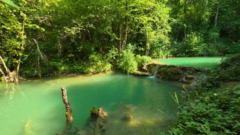 Lush green forest frames crystal-clear turquoise water. Bigar Waterfall, Serbia 動画素材 346249728