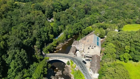 Lush green forest surrounds a historic stone bridge. Yorkshire Dales,  Ribb.. Stock Footage 346287963