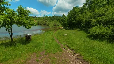 Lush green grass borders calm lake waters. Vrmdza Lake, Serbia Stock Footage 338024334