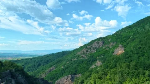 Lush green hills roll under bright blue skies. Sokolica rock, Serbia Stock Footage 341129444