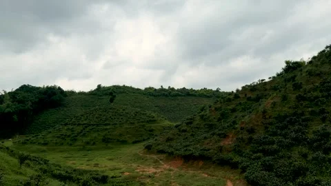 Lush green hills under a dramatic cloudy sky creating a serene and pictures.. Vidéo 339369210