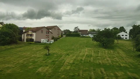 The lush green landscape captured from a train window at Switzerland Stock Footage 315215419