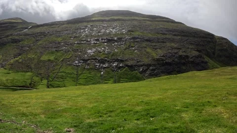 Lush green meadow and massive volcanic mountain in Saksun, Faroe Islands Stock Footage 339481929