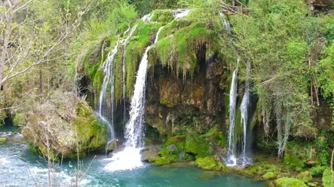 Lush Green Moss-Covered Cliffs with Multiple Cascading Waterfalls Stock-Footage 301088436