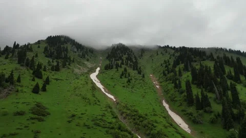 Lush green mountains with winding river and misty clouds in the background Stock Footage 336964018