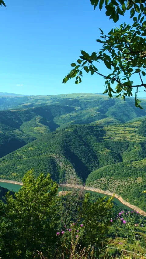 Lush green valley frames a winding river below. Kozji Kamen viewpoint, Serbia 스톡 동영상 342343139