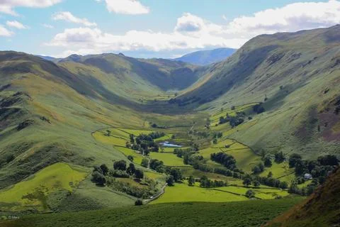 Lush green valley with a patchwork of rolling hills and lush grassy fields. 스톡 사진