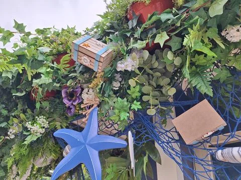 Lush greenery with decorative boxes and blue starfish accents Stock Photos