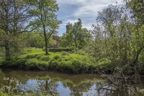 Lush greenery frames a calm river under bright skies Stock Photos