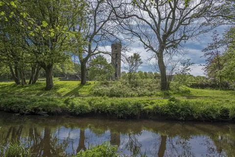 Lush greenery frames a quiet riverbank Stock Photos