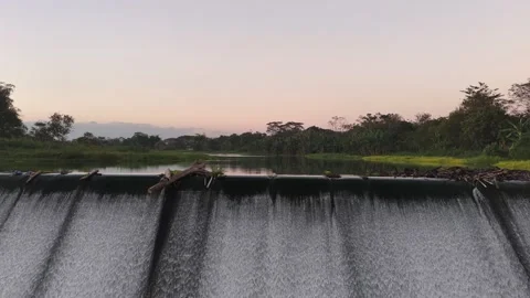 Lush Riverscape Reveal over a Java Dam at Sunset. Stock Footage 338419774