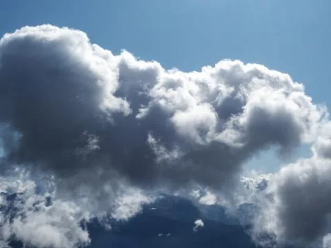 Lush white cloud on a background of a valley and blue sky Stock Photos