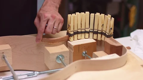 Luthier adds clips to fix lining on acoustic guitar Stock Footage 117966227