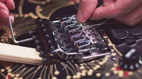 Luthier fix guitar bridge while changing strings Stockbeeldmateriaal 117987674