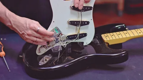 Luthier fixing electrical components of a guitar Video stock 118015806