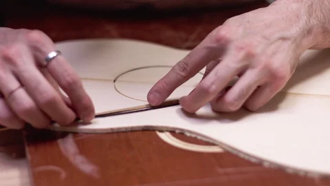 Luthier insert the rosette into the guitar body Video stock 112004571