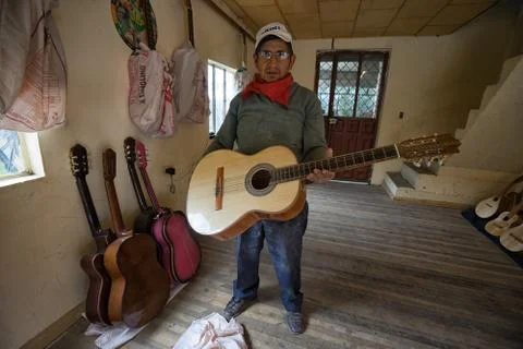 Luthier man standing with a finished classical guitar Stock Photos
