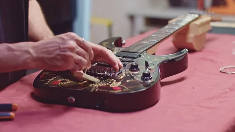 Luthier removes old strings from guitar Stock Footage 117985426