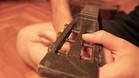 Luthier replacing old string on vintage guitar headstock Video stock 341376365