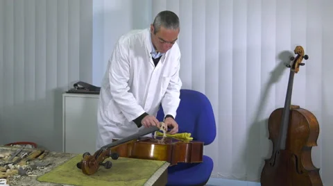 Luthier sets up and adjusts the easel Stock Footage 61915381