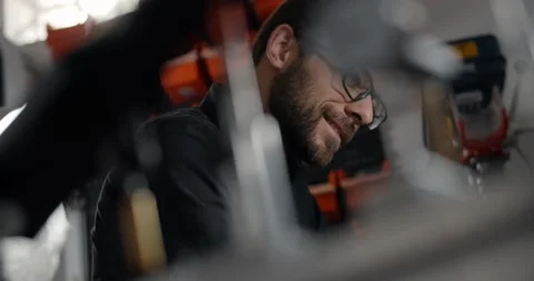 Luthier smiles when working at his workshop, repairing the musical instruments Video stock 165620227