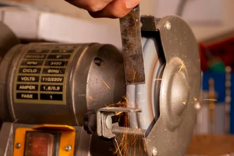 Luthier using grinder to prepare metal part Stock Photos
