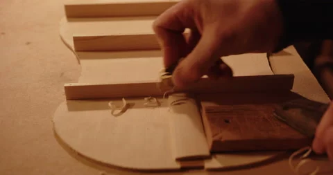Luthier working on a Ukulele or Guitar with a plane Stock Footage 169194628