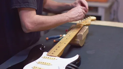 Luthier wrap strings of a guitar Video stock 118017957