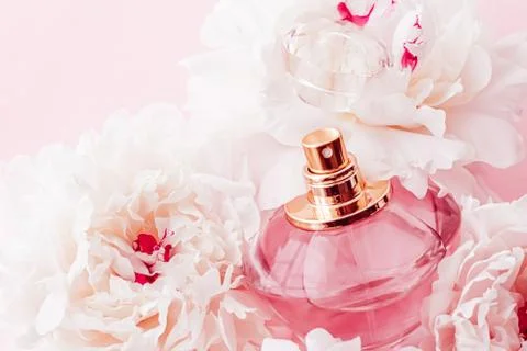Luxe fragrance bottle as girly perfume product on background of peony flowers Stock Photos