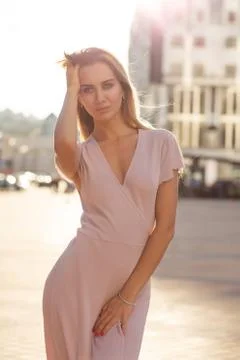 Luxurious blonde model wearing knitted dress enjoying warm summer evening at  Stock Photos