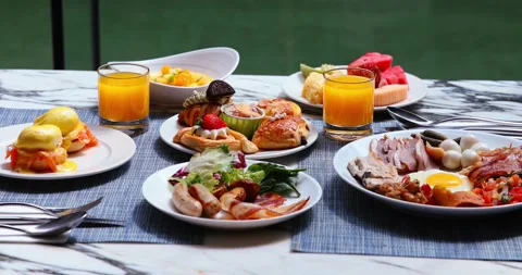 Luxurious breakfast spread with eggs Benedict, pastries, fresh fruit, Video stock 318119939