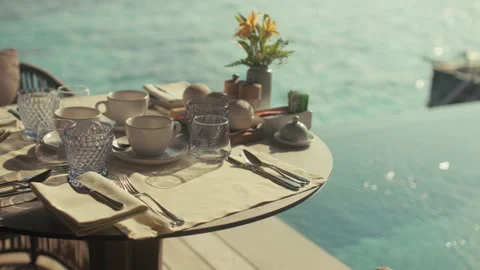 Luxurious breakfast table for three set over turquoise tropical waters  Stock Footage 327084972