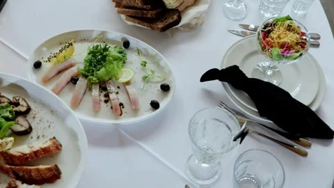 Luxurious dining presentation with sashimi, crisp salads, artisan bread plated Stock Footage 331463407