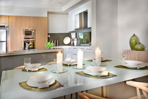 Luxurious dining room table set up near to the kitchen Stock Photos