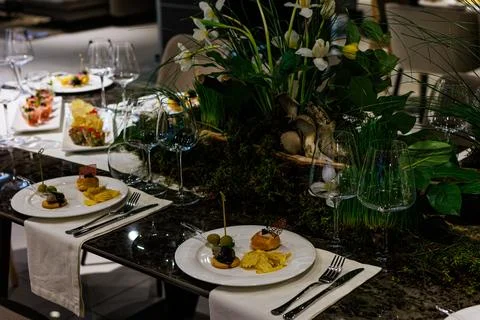 Luxurious dining table setup featuring gourmet appetizers, elegant glasswar.. Stockfoto's