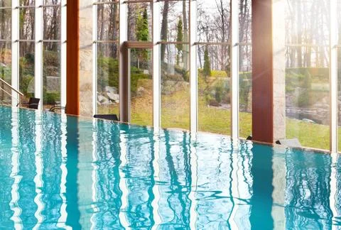 Luxurious empty infinity swimming pool with big glass windows with nature vie Stock Photos