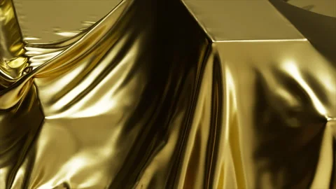 Luxurious flowing gold fabric draped over geometric shapes, creating a rich, ele Stock Footage 314932197
