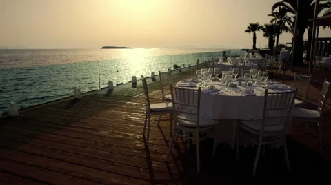 Luxurious formal dinner table outdoors at sunset with sea view Stock Footage 41121897
