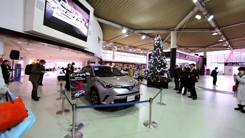Luxurious gray car and visitors looking at it in Toyota Mega Web. Tokyo, Japan Stock Footage