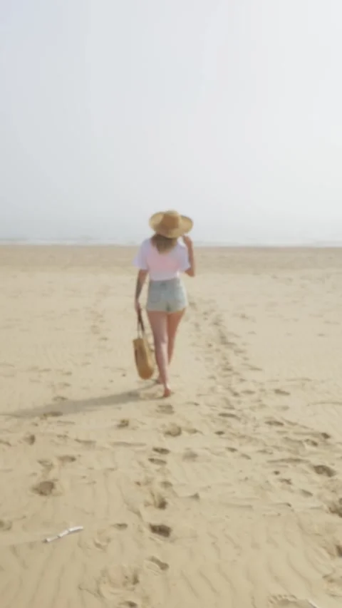 Luxurious lady walking beach in front blue calm ocean wearing straw wide br.. Stock Footage 269380431