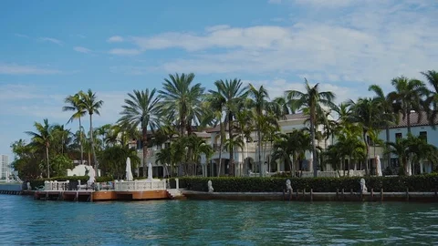 Luxurious mansion between palm trees and private dock on star island on sunny Stock Footage 101134160