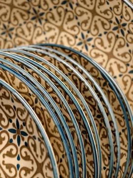 Luxurious patterned ceramic plates with blue rim on shelves in store, close.. Stock Photos