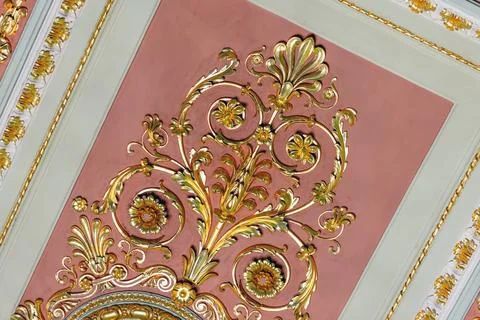 Luxurious pink ceiling panel featuring gilded floral scrolls and intricate .. 写真素材