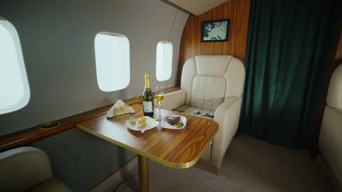 Luxurious private jet cabin interior featuring champagne and dessert on woo.. Stock Footage 337601819