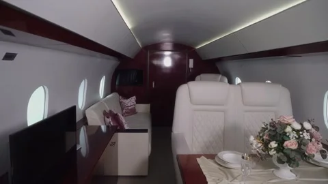 Luxurious private jet interior showcasing elegant seating, plush cushions, and a Video stock 328480865